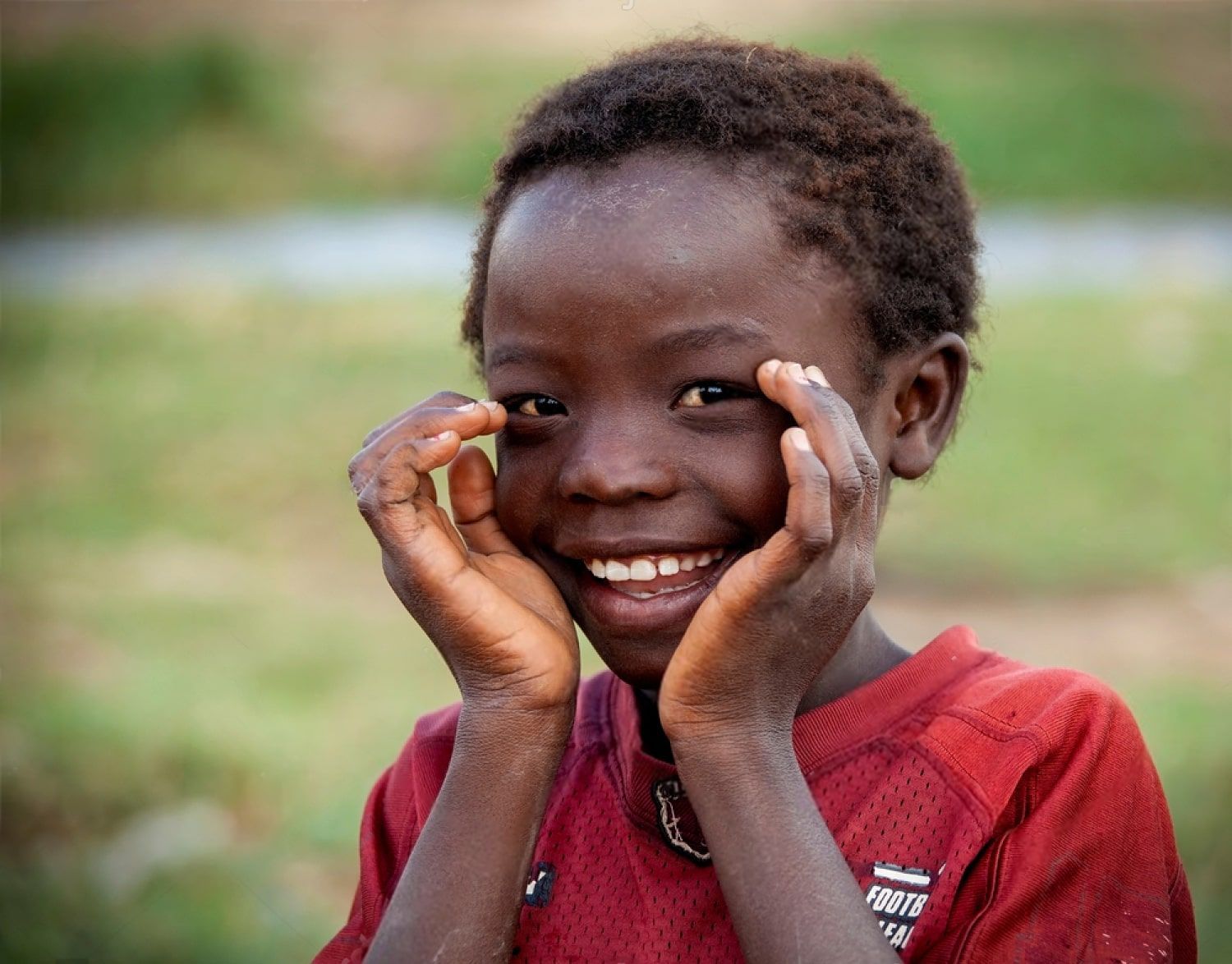 stock-photo-lubumbashi-democratic-republic-of-the-congo-november-a-smiling-boy-holds-up-his-hands-1741880474-min